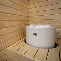 Valkoinen kiuas upotettuna lauteisiin.